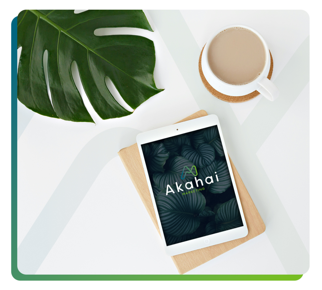 iPad showing Akahai logo sitting on a desk with a cup of coffee and large plant
